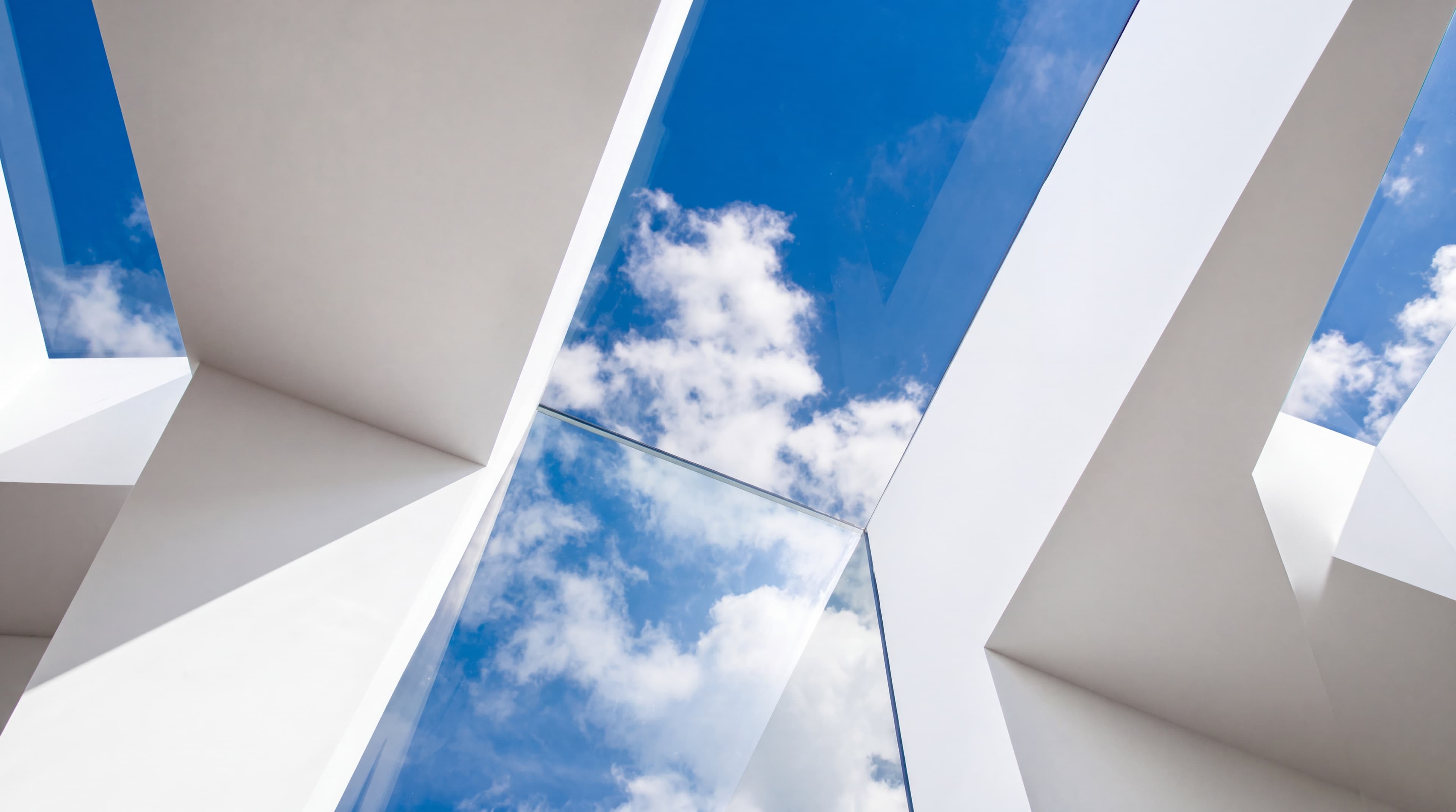 Looking up through a spotless glass skylight to a bright blue sky